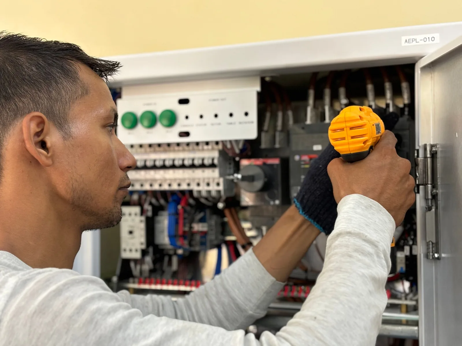 An electrician working on a commercial control panel, for subpanel installation in Hartford