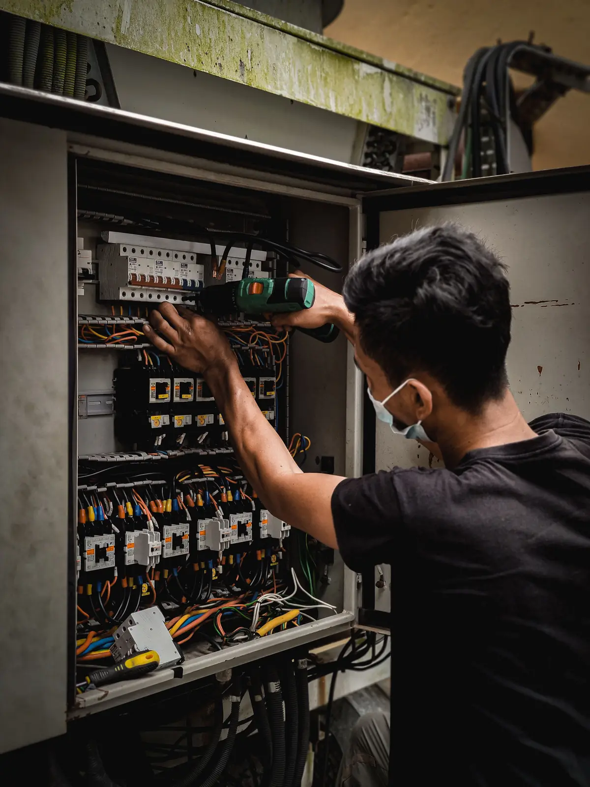 An electrician working inside a large distribution board, for commercial electrical in Hartford