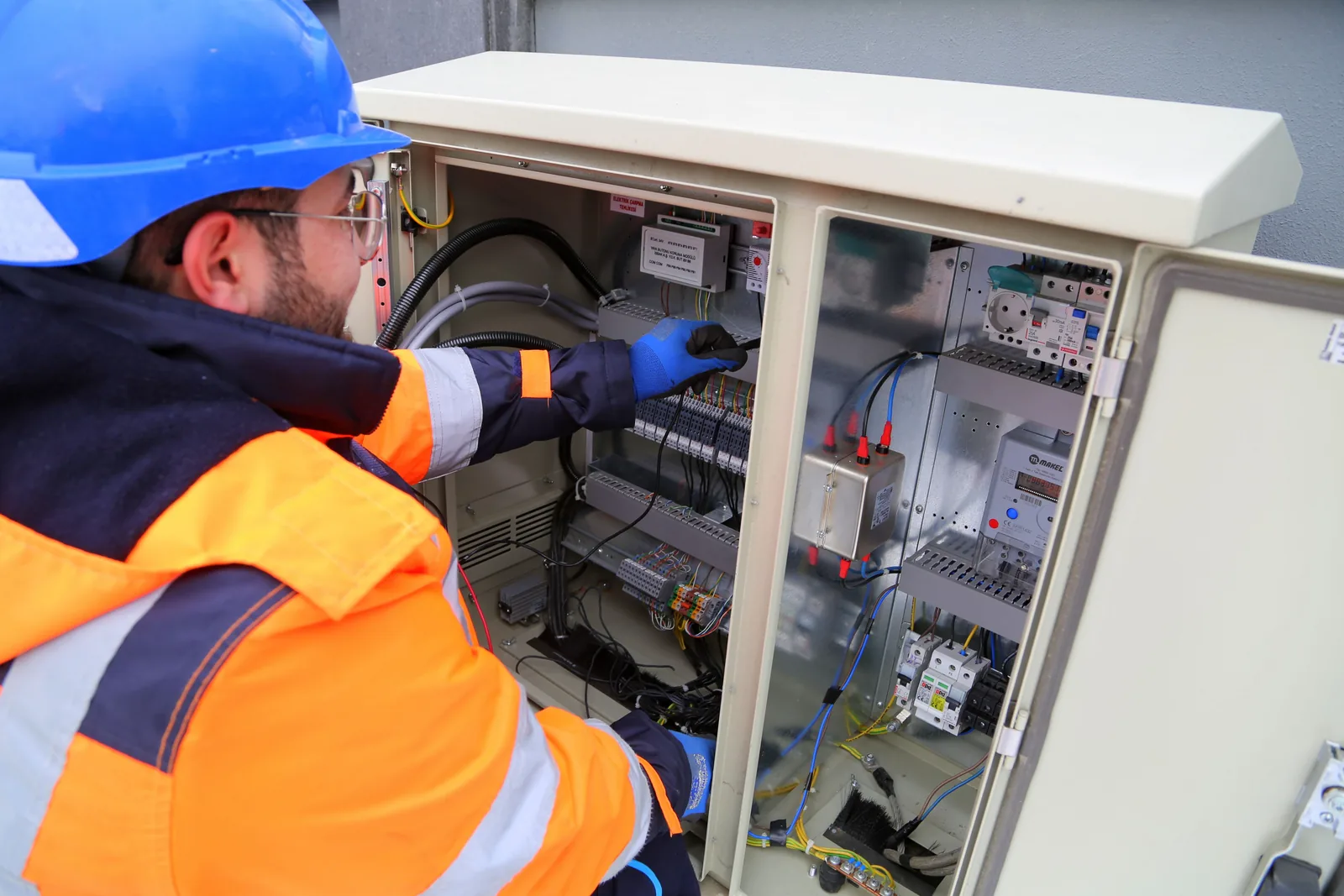 An electrician working in an outdoor service cabinet, for surge protection in Hartford